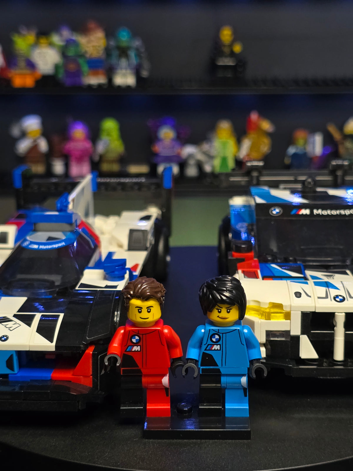 Close-up of the two BMW driver figures between the cars