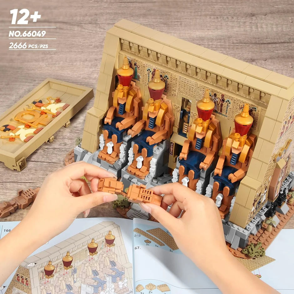 Hands arranging figures inside the open Egyptian temple